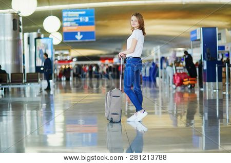 Young Woman In International Airport Walking With Luggage, Ready For Her Flight