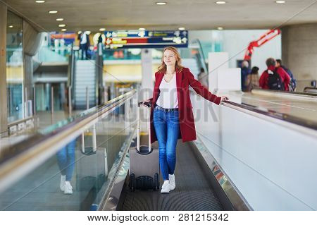 Young Woman In International Airport With Luggage On Travelator
