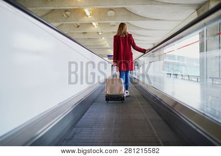 Young Woman In International Airport With Luggage On Travelator