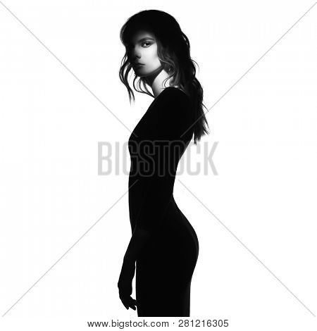 Black and white art fashion portrait of beautiful woman with a beam of light on her face. Model posing on white background.