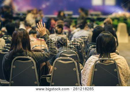 Speaker On The Stage With Rear View Of Audience In Put Hand Up Acton For Question In The Meeting Or 