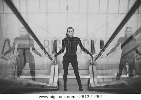 Sexy Girl In Dark Outfit Standing On Escalator. Woman With Slim Body In Metro. Girl Looks Sexi, Desi