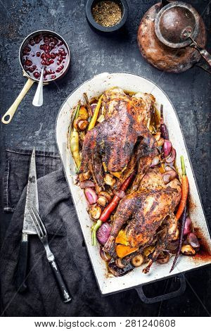 Traditional barbecue pheasant with vegetable and cranberry sauce as top view in a stewpot 