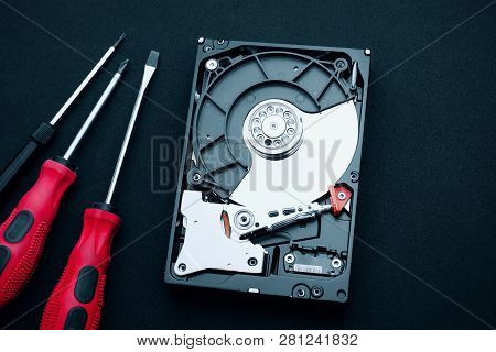Top View Of Uncovered Hard Drive And Screwdrivers On The Desk. Hardware Assembly Inside Showing Magn
