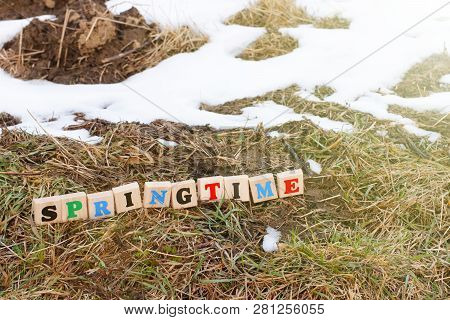 A Colorful Inscription Spring Made Up Of Wooden Cubes Stands On A Plowed Field In Spring. The Beginn