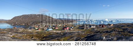 Rodebay, Greenland - July 09, 2018: Colorful Wooden Houses With Icebergs In The Background. Rodebay,