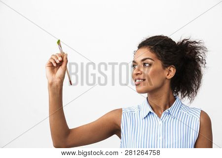 Beautiful young african woman atrist holding a paint brush over white background