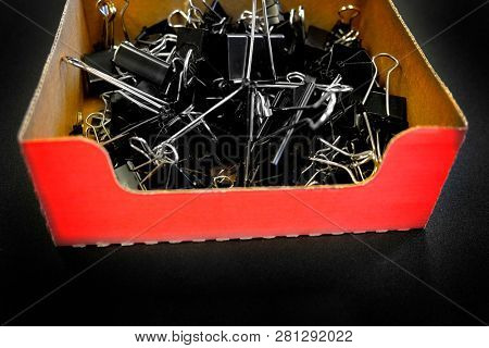 Box of binder clips binderclips office supplies of paperclips on desk