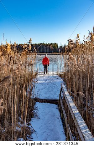 Man Standing At A Jetty Between Reed