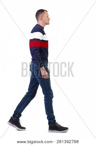 Side view of going  handsome man in pullover. walking young guy . Rear view people collection.  backside view of person.  Isolated over white. Stylish man walks by carefully looking in front of him.