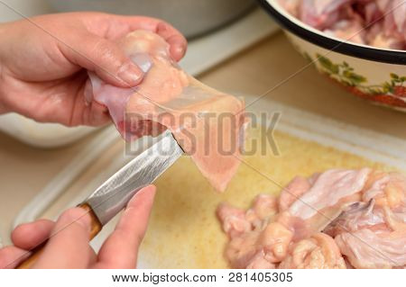 Woman Cuts Off Excess Chicken Skin, Close Up