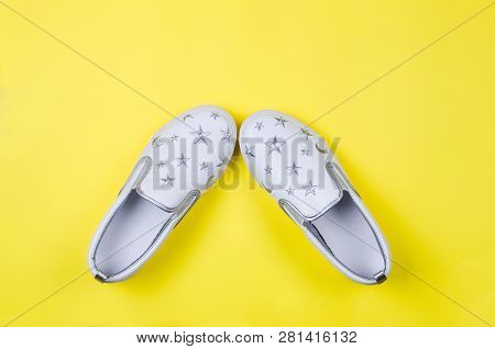 Women Or Teenage Fashion, White Slipons, Stylish Shoes On Yellow Background. Beauty And Fashion Conc