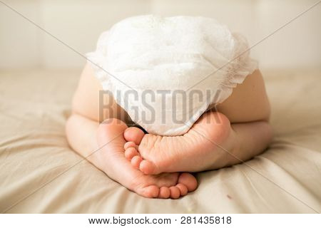 Small Child Is Sleeping In A Diaper. White Diaper. Little Fingers