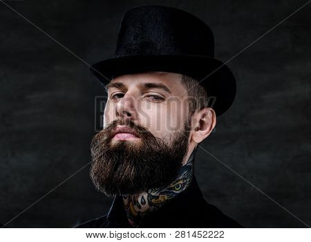 Close-up Portrait Of An Old-fashioned Bearded Man With Tattoos On His Neck Wearing A Top Hat, Isolat