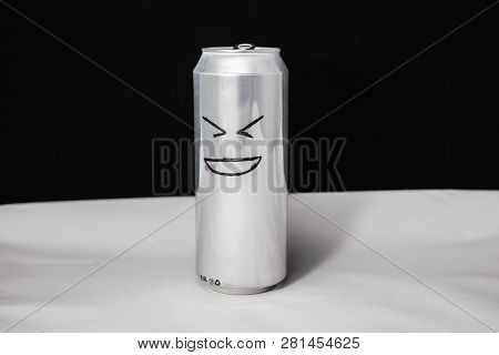 Concept Of Laugh Man. Grinning Emoticon On Aluminium Can, Emoji With Xd Face. On Black Background