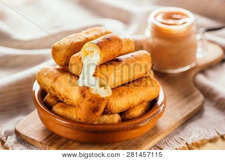 Cheese Fingers, Typical Venezuelan Appetizer Called Tequeños Accompanied With A Pink Sauce On A Wood