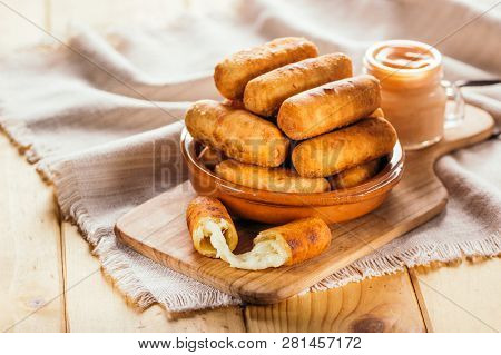 Cheese Fingers, Typical Venezuelan Appetizer Called Tequeños Accompanied With A Pink Sauce On A Wood