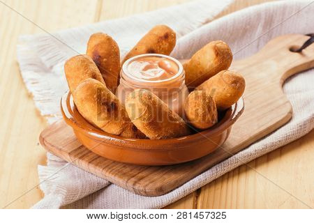 Latin-american Appetizers Called Tequeños Made Of Fried Corn Filled With Cheese With A Pink Sauce