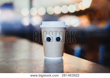 Coffee Takeaway Cup With Cartoon Eyes In Cafe. Concept Of Hospitable Cafe