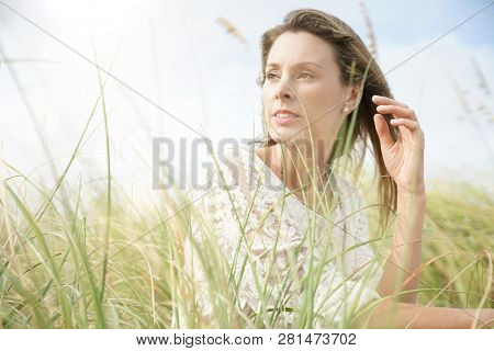 Portrait of attractive woman sitting in wildgrass