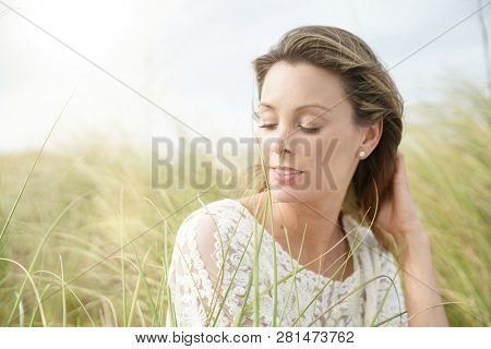 Portrait of attractive woman sitting in wildgrass