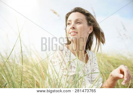 Portrait of attractive woman sitting in wildgrass