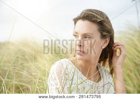 Portrait of attractive woman sitting in wildgrass