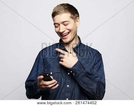  Happy young  man in glasses typing sms on white background