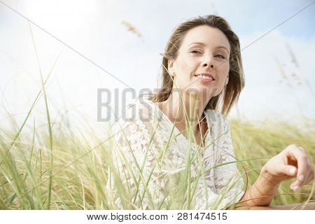 Portrait of attractive woman sitting in wildgrass
