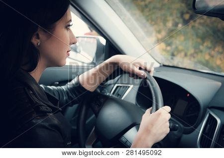View From The Inside Of A Car On Attractive Woman Waiting Patiently In Car. Cute Brunette Girl Sitti