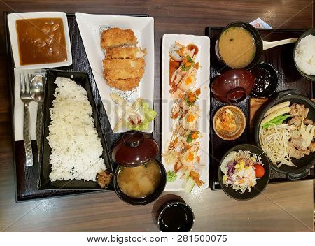 Top View Of Sliced Pork Cutlet With Vegetable Salad, Curry, Rice, Miso Based Soup, Grilled Pork And 