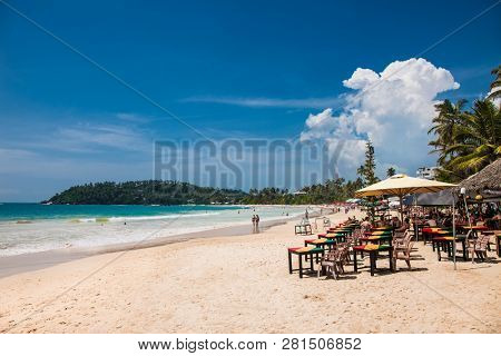 Mirissa Beach, Sri Lanka - JAN 2, 2017:  Tourists walking on the sand while enjoying the view across the wonderful beach of Mirissa on Jan 2, 2017. Sri Lanka.