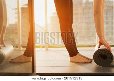 Girl Wearing Grey Sporty Pants Rolling Fitness Mat Before, After Class In Yoga Studio Club Or At Hom