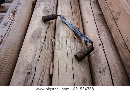 Antique Carpentry Tool Folding Drawknife On The Background Of Wooden Logs