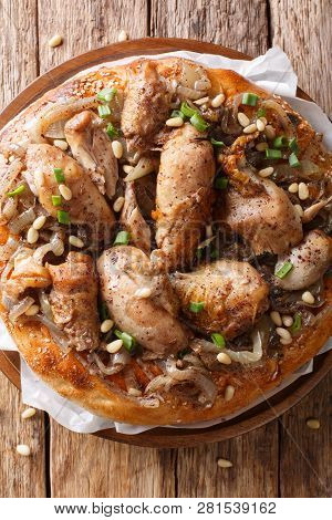 Palestinian Dish Of Chicken With Sumac, Pine Nuts And Onions On A Flat Bread Closeup. Vertical Top V