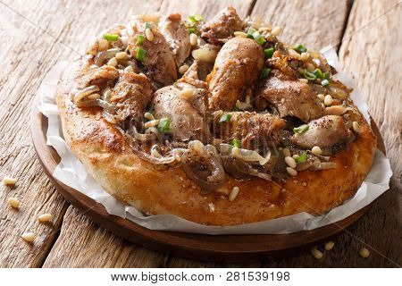 Palestinian Dish Of Chicken With Sumac, Pine Nuts And Onions On A Flat Bread Closeup. Horizontal