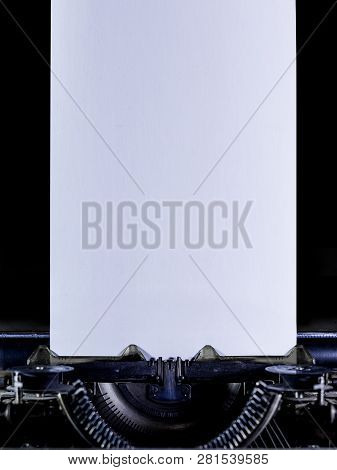 Typewriter On A Black Background With Clear White Long Page. Vertical Orintation