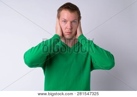 Young Handsome Man Covering Ears As Three Wise Monkeys Concept