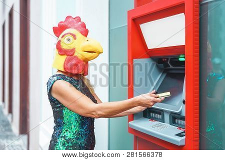Mature Woman Wearing Cock Mask Withdraw Money From Bank Cash Machine With Debit Card - Surreal Image