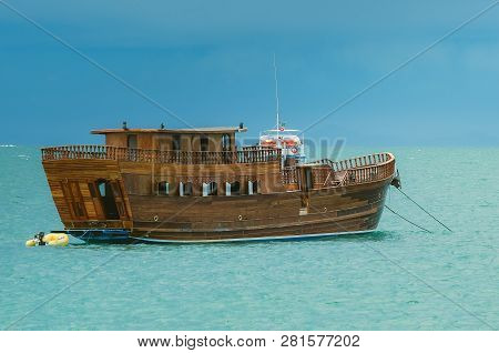Bombinhas - Sc, Brazil - December 21, 2018: Wooden Tourism Boat Anchored On The Sea Of The Beach At 