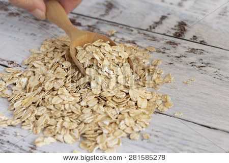 Dried Oats Or Oatmeal In Spoon On The Wood Table. Its Are A Nutrient-rich Food Associated With Prote