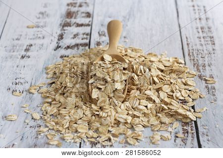 Dried Oats Or Oatmeal In Spoon On The Wood Table. Its Are A Nutrient-rich Food Associated With Prote
