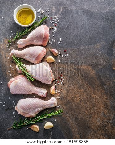 Chicken legs with spices and salt  ready for cooking on cutting board.