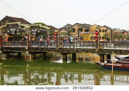 Hoi An, Vietnam - February 12, 2018: Bridge Across To The Thu Bon River With Tourists And Domestic P