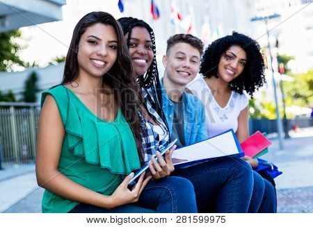 Latin American Female Student Looking At Camera With Group Of International Students Outdoor In The 