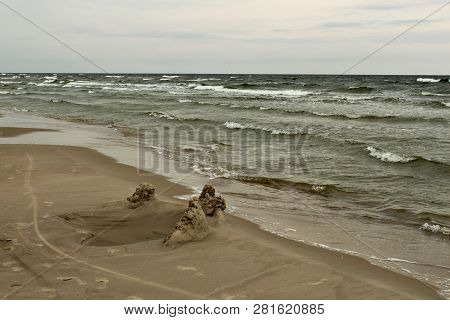 Waves Of Baltic Sea And A Beach With Yellow Sand During Windy Cloudy Weather