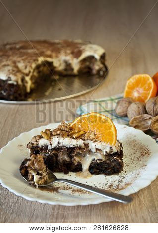 Closeup Photo Of A Carrot Cake Sprinkled With Walnuts And Mandarine Slices On Top