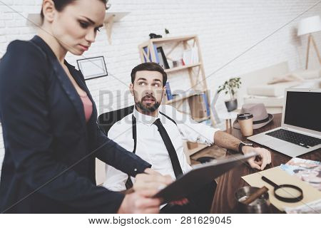 Private Detective Agency. Man With Holsters And Woman Are Looking At Tablet In Office.