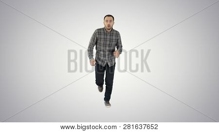 Man Starting To Run In Casual Clothes On Gradient Background.