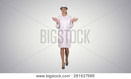 Female Engineer Walking And Talking To Camera Presenting Something On Gradient Background.